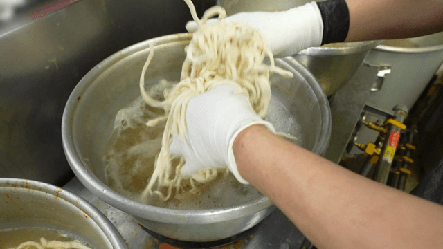 Noodles being prepared in a kitchen