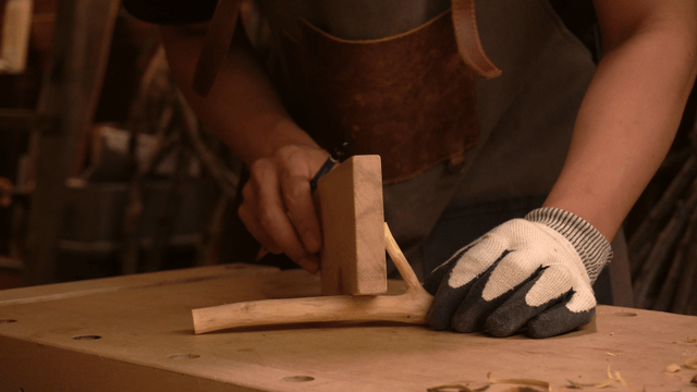 Woodcraft artisan marking a wooden piece with pencil in workshop