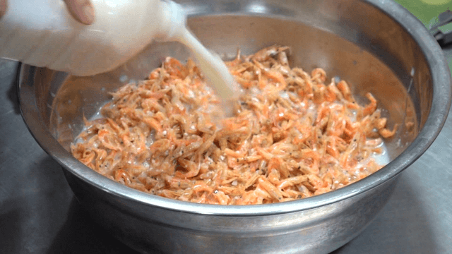 Soybean broth poured over shrimp in a stainless bowl