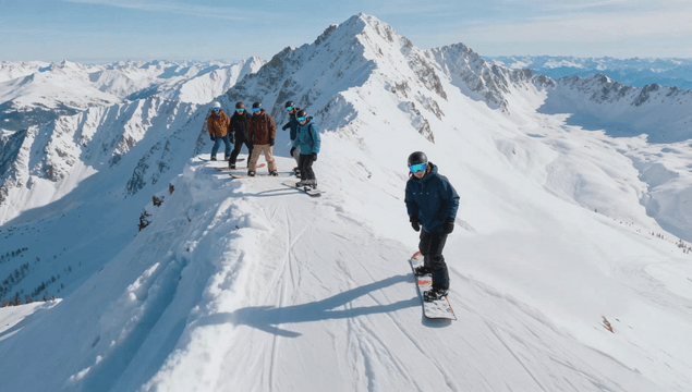 Snowboarders riding at snowy peak