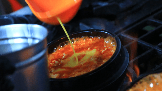 끓고있는 순두부찌개에 계란을 넣는 장면