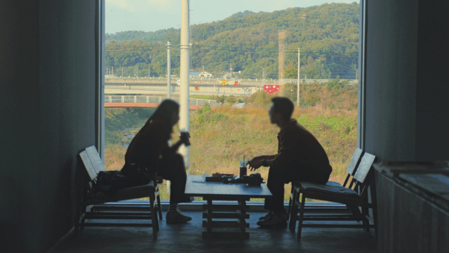 Two people talking in a cafe with a view