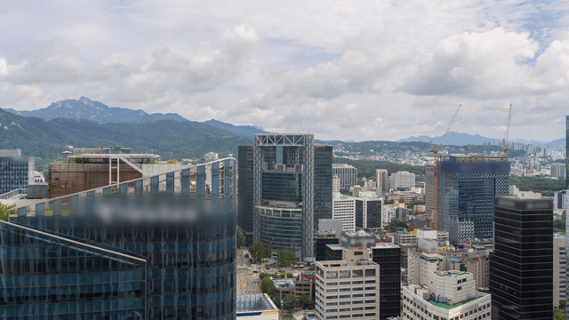 Cityscape of tall skyscrapers with mountains in the background