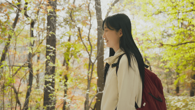 Woman walking on autumn forest trail