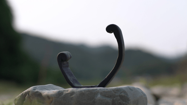 Curved wooden sculpture on natural rock