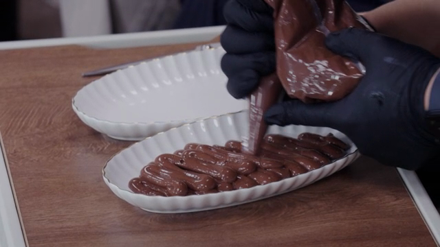 Chocolate mousse being piped onto a plate