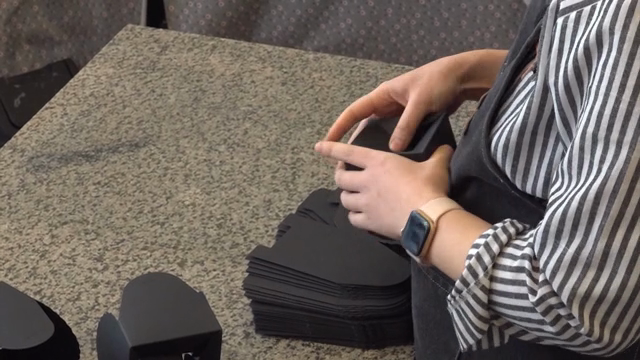 Person assembling black paper boxes