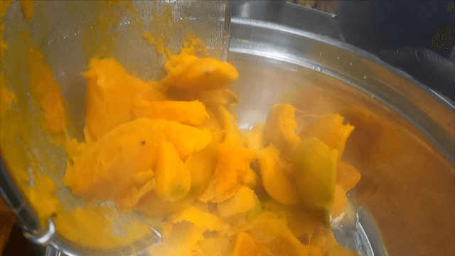 Ladle lifting boiled pumpkin pieces