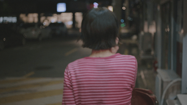 Woman walking on a night street while on a call