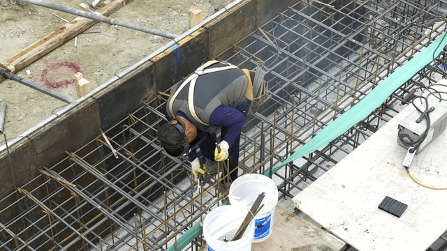 Construction worker welding steel bars