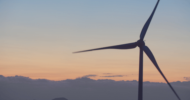 Wind turbine against a sunset sky
