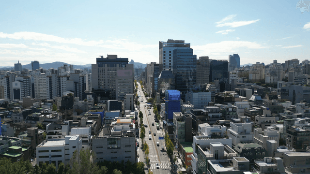 Bustling Seoul cityscape with a long straight boulevard on a clear day