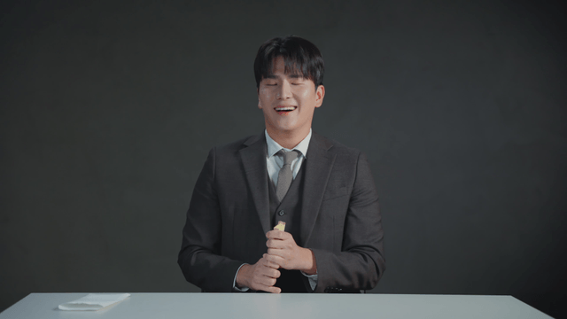 Man in a suit counting money at a desk with a satisfied expression