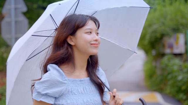 우산을 들고 길을 걷는 여성