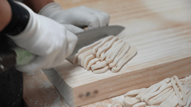 Handmade noodles being prepared on a board