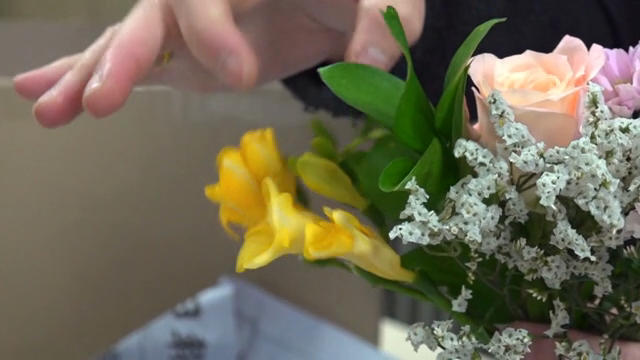 A person arranging a colorful bouquet