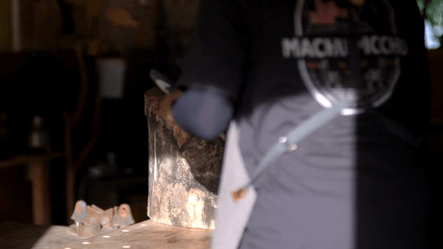 Carpenter in woodworking studio with wooden logs and apron