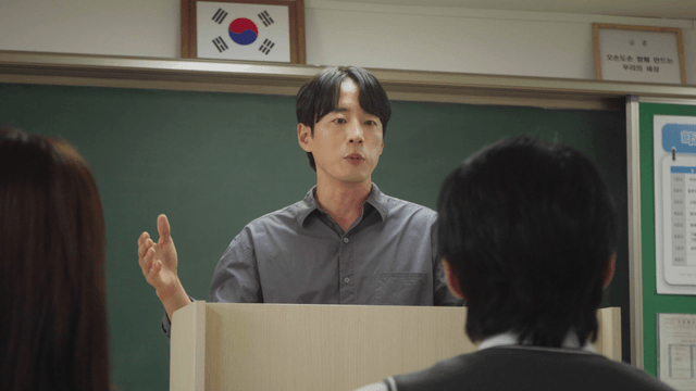 Teacher gesturing while teaching in the classroom