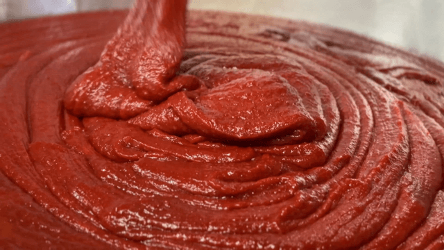 Red pepper paste being poured into large pot