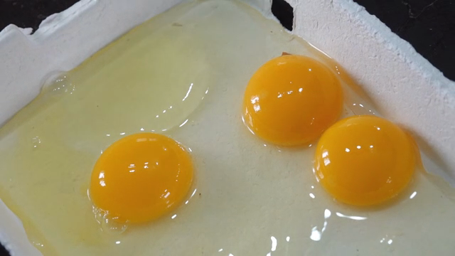 Three egg yolks in a carton