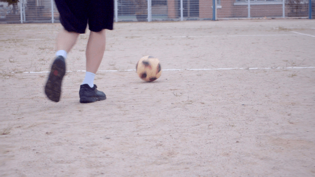 흙바닥에서 축구를 하는 사람