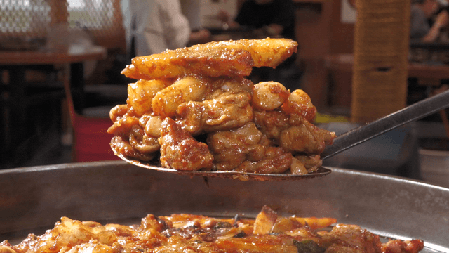 Spicy stir-fried chicken scooped with a spatula