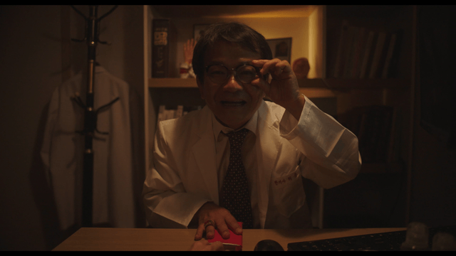 Doctor holding red envelope in dark office