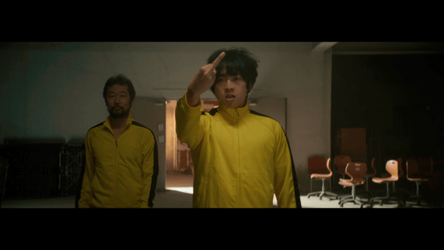 Man making a rude gesture in a yellow tracksuit