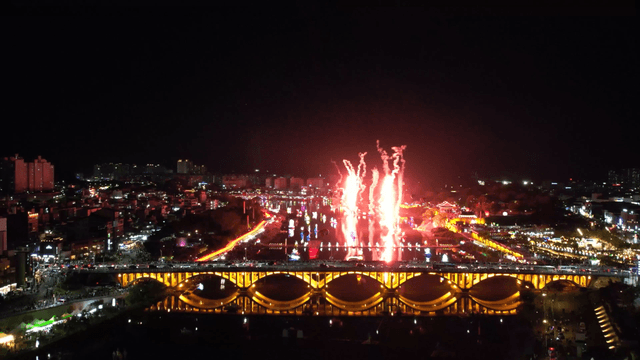 Night cityscape with fireworks and bridge
