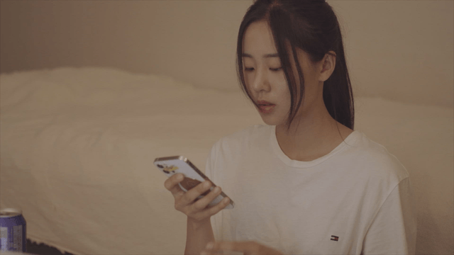 Woman sitting in front of a bed and answering a phone call
