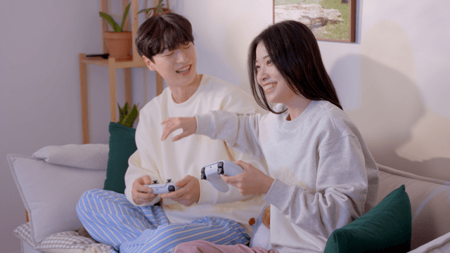 Couple enjoying console video game together on sofa