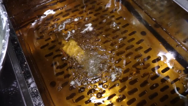 Ice cream coated in batter being fried