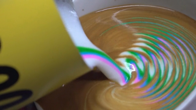 Colorful latte art being poured into coffee