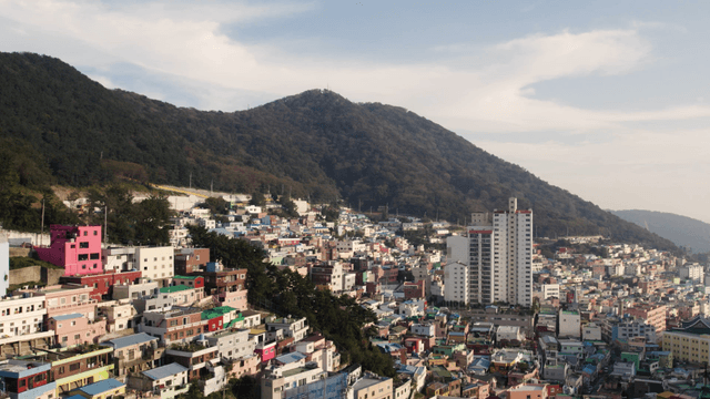 Colorful hillside village with mountain backdrop