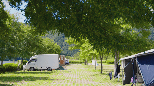 Summer campsite with a camper under warm sunlight