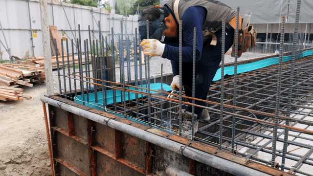 Construction worker welding steel bars