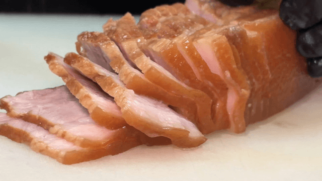 napa wraps with pork being sliced thinly on a cutting board