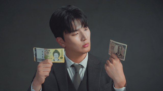 Man smiling at the Japanese yen in his hand