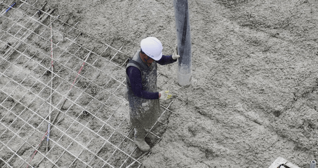 Worker pouring concrete at a construction site