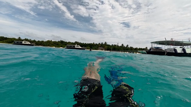 Swimming in clear turquoise waters near boats