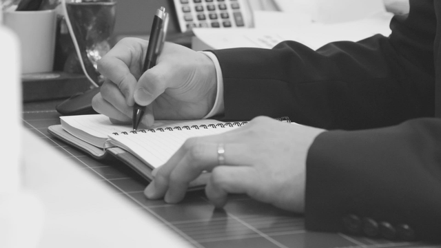 A person writing notes on a paper