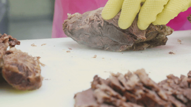 Slicing cooked meat on a cutting board