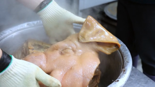 Boiling pork head in a large pot
