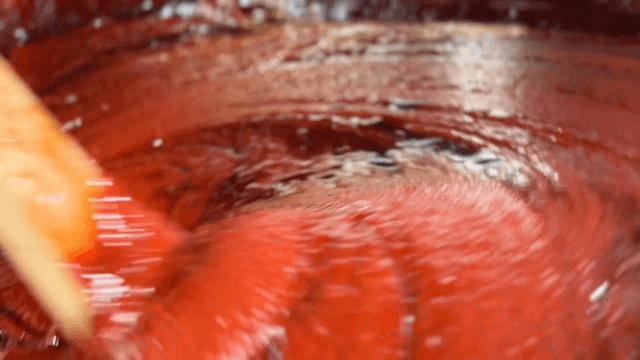 Wooden spatula mixing red pepper paste and green plum extract