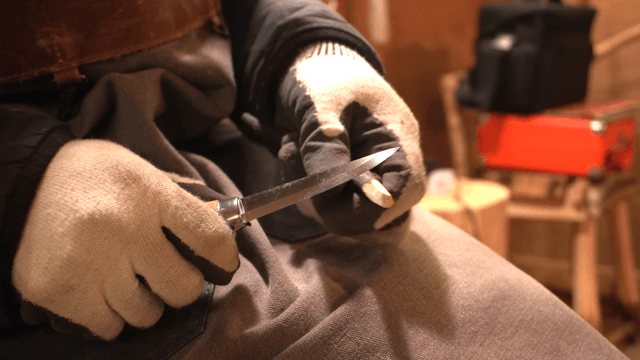 Artisan carving wood with a knife