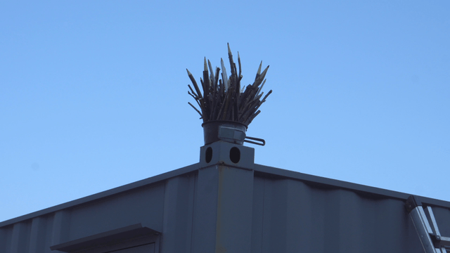 Wooden pencil sculpture placed on a roof