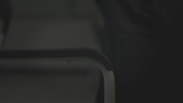 Person rising from chair with clenched fist