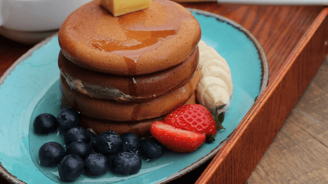 Pancakes with butter and syrup served with fruit