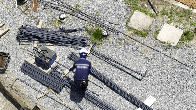 Construction worker handling steel rods