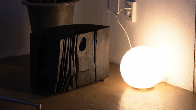 Shining lamp beside a black wooden block